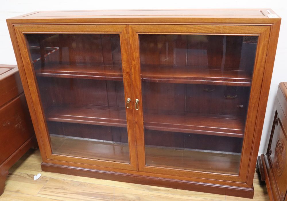A Chinese hardwood glazed low bookcase, width 122cm, depth 25cm, height 92cm